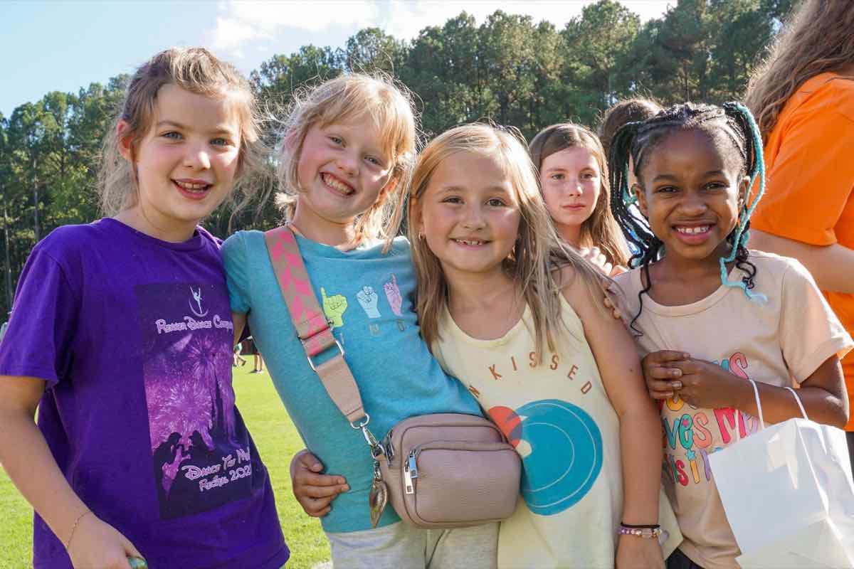 Five smiling girls standing together on the field at last year’s Fall Festival