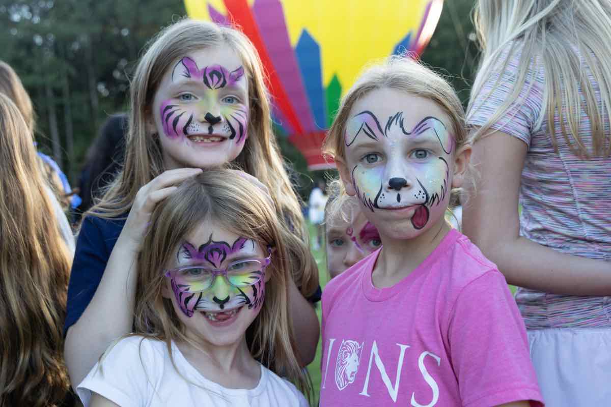 Three children with colorful tiger and cat face paint